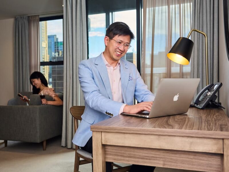 A guest using laptop with hotel Wi-Fi at Brady Hotels room desk.
